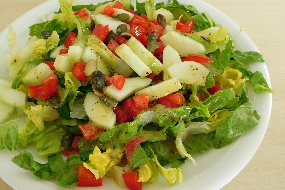 Blattsalat mit Paprika, Gurke, Kürbiskernen in leckerem Senfdressing