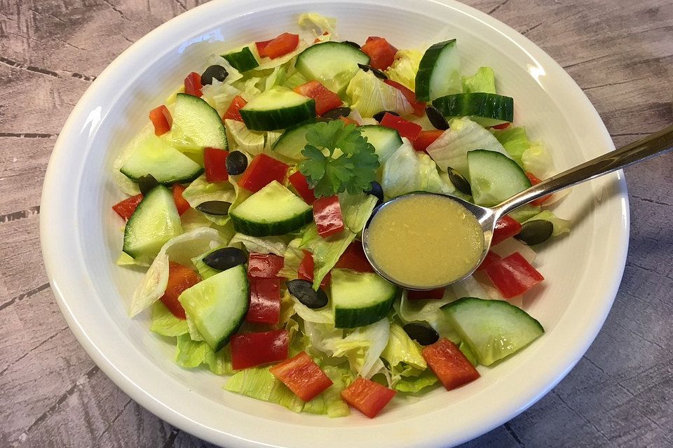 Blattsalat mit Paprika, Gurke, Kürbiskernen in leckerem Senfdressing