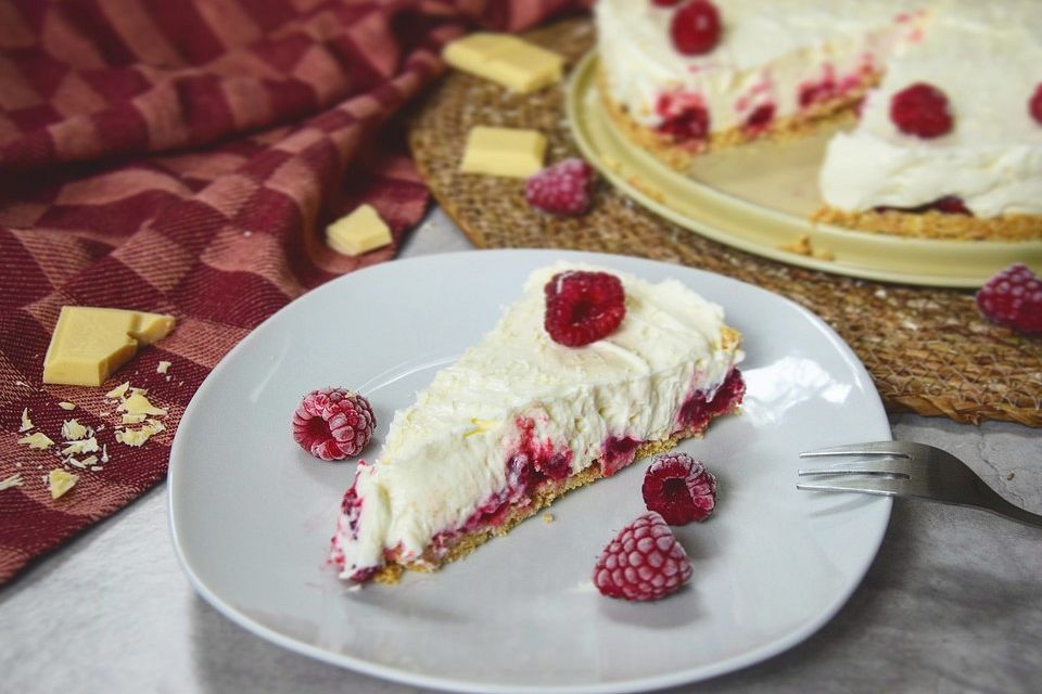 Käsekuchen mit Himbeeren und weißer Schokolade