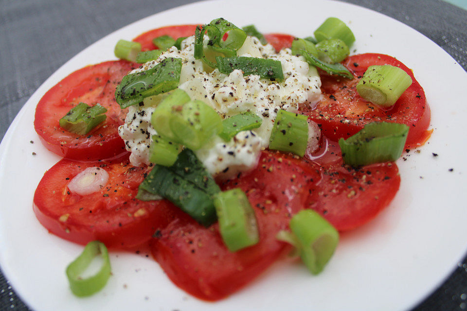 Tomaten-Carpaccio mit körnigem Frischkäse und Frühlingszwiebeln