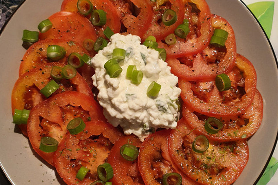 Tomaten-Carpaccio mit körnigem Frischkäse und Frühlingszwiebeln