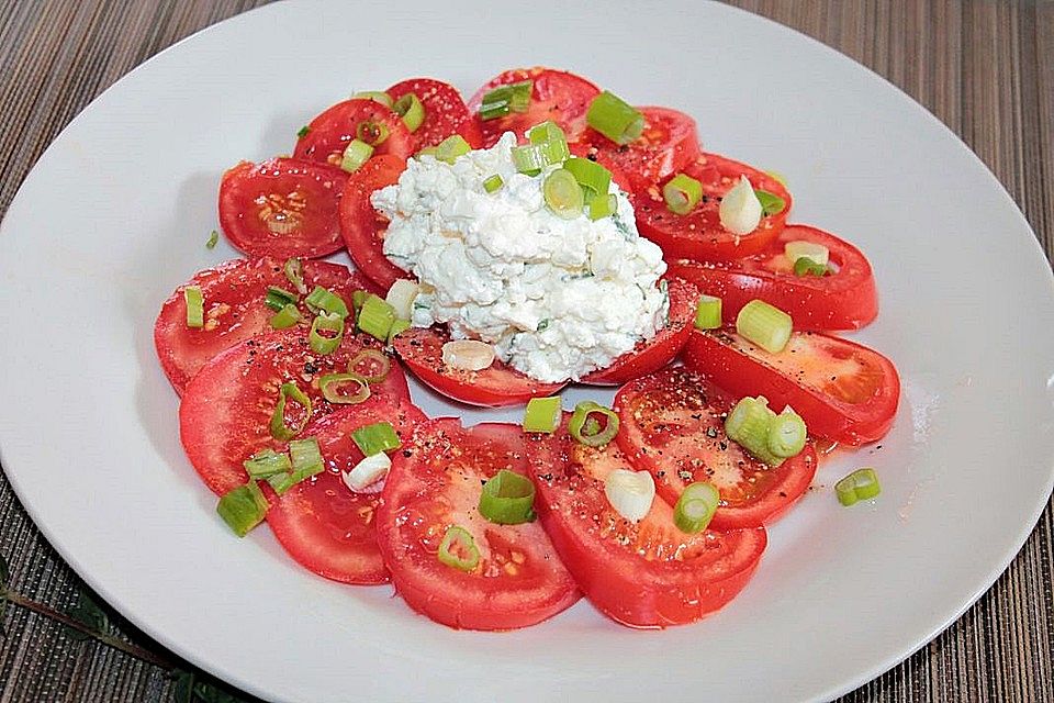 Tomaten-Carpaccio mit körnigem Frischkäse und Frühlingszwiebeln