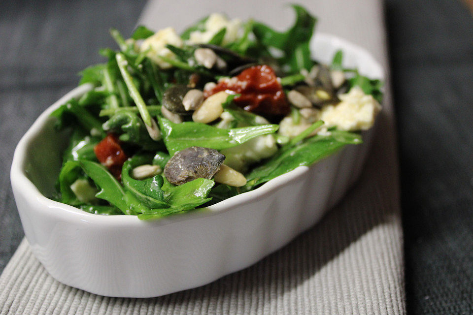 Rucolasalat mit getrockneten Tomaten, Feta-Käse und Pinienkernen