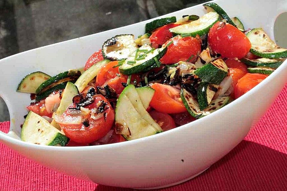 Tomatensalat mit Röstzwiebeln und gebratenen Zucchini in Senfdressing