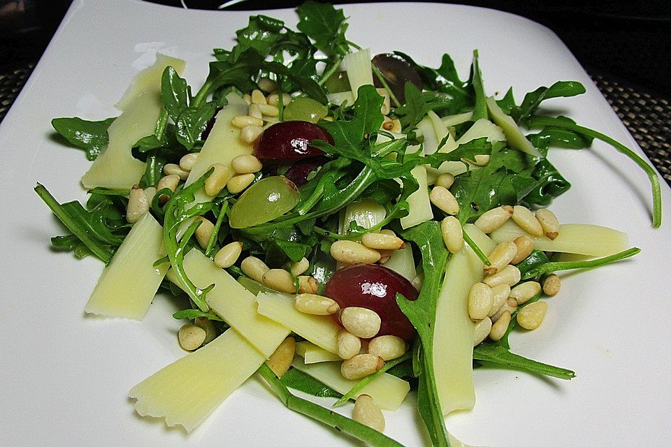 Rucola-Trauben-Salat mit Käsestreifen und gerösteten Pinienkernen