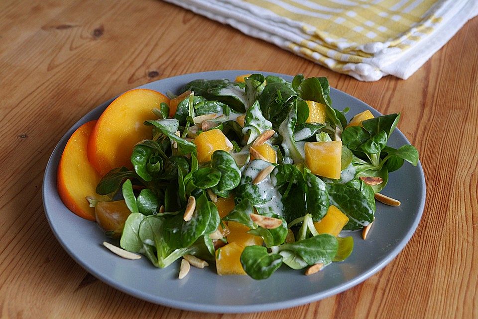 Feldsalat mit Kaki und gerösteten Mandeln in Joghurtdressing