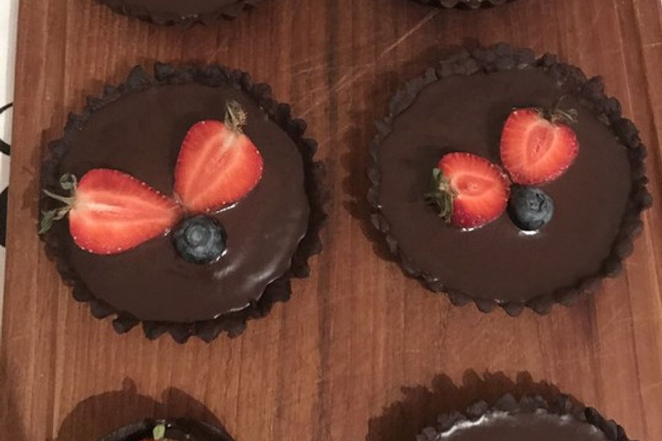 Dunkle Schokoladen-Tartelettes mit Erdbeeren