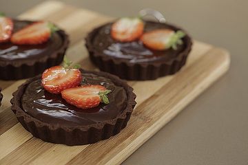 Dunkle Schokoladen-Tartelettes mit Erdbeeren