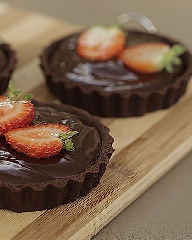 Dunkle Schokoladen-Tartelettes mit Erdbeeren