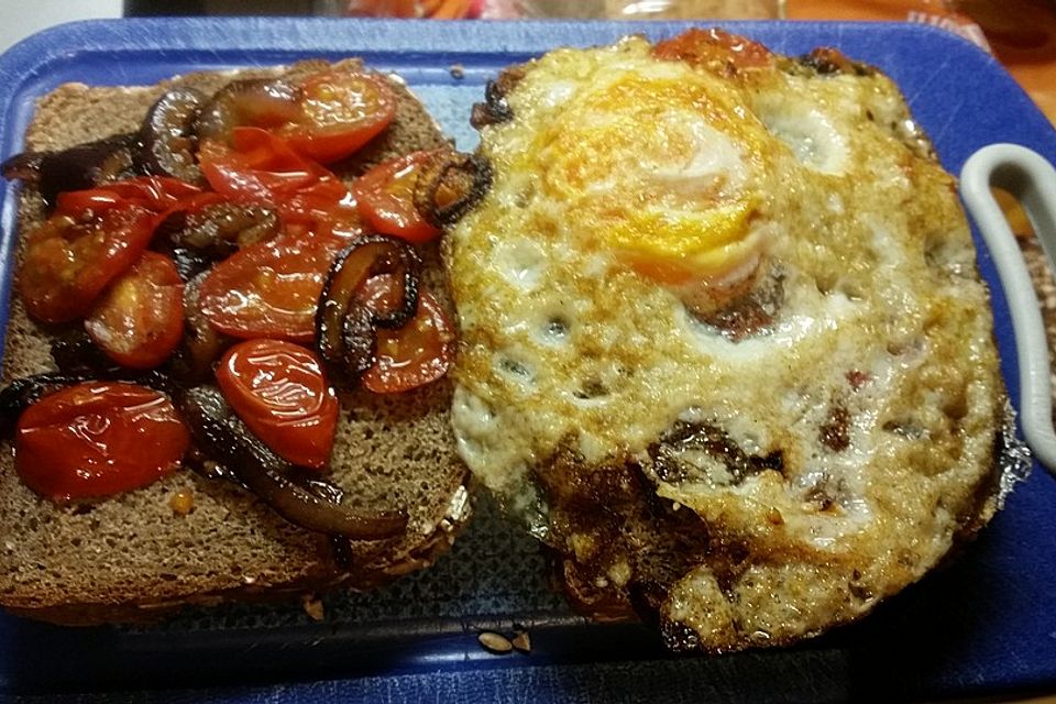 Tomaten-Zwiebel-Pfanne auf Bauernbrot mit Spiegelei