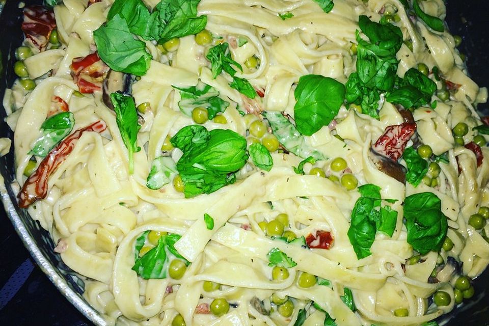 Tagliatelle mit getrockneten Tomaten, Schinken, Erbsen und Champignons