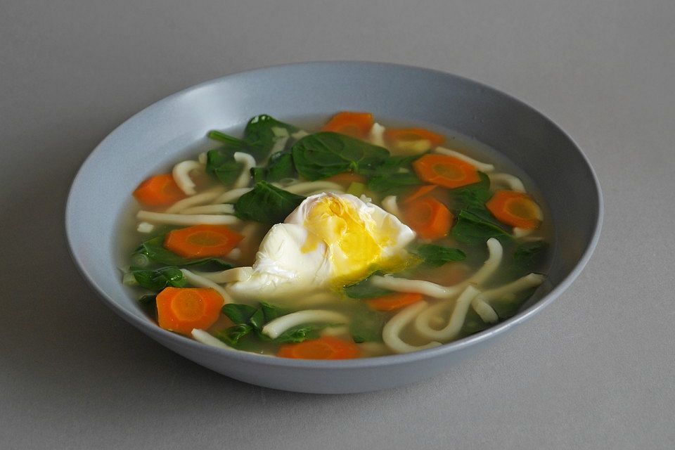 Udon-Nudelsuppe mit Spinat, Möhren und pochiertem Ei