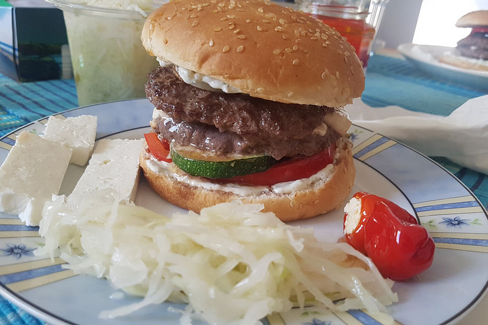 Burger griechischer Art mit Schafskäse gefülltem Bifteki