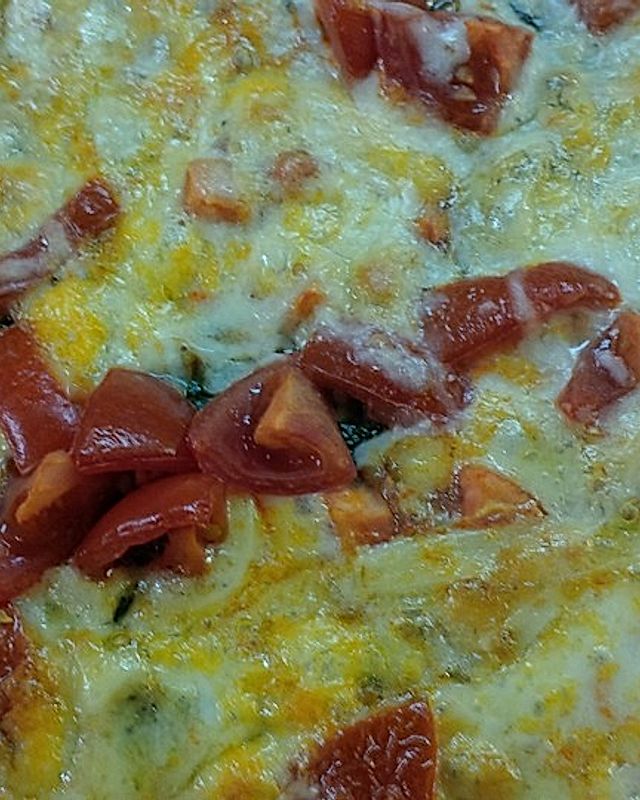 Pizza mit Tomaten und Käse auf Spinat-Teig