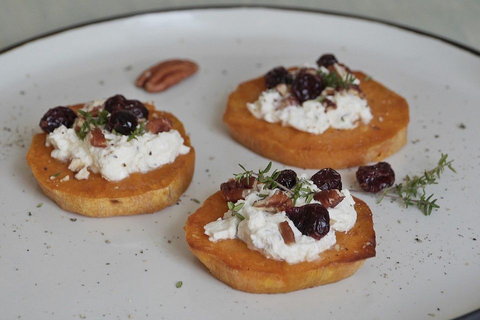 Gebackene Süßkartoffelscheiben mit Ziegenfrischkäse, Pekannüssen, Cranberries und Thymian