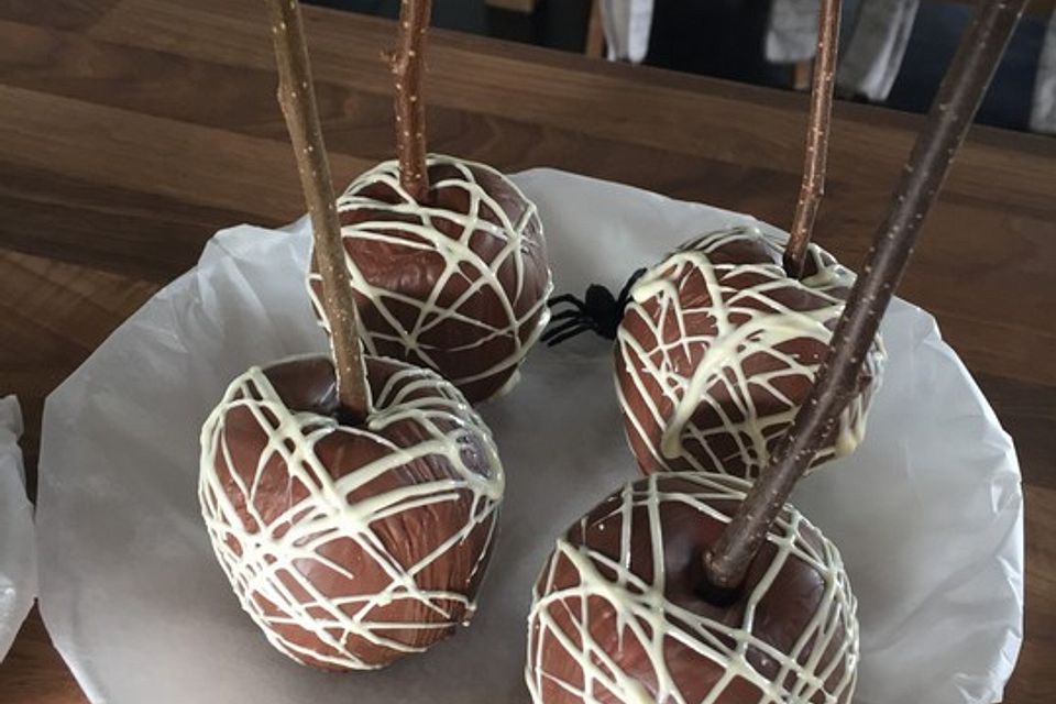 Halloween-Schoko-Äpfel am Stiel mit Spinnweben