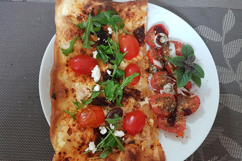 Flammkuchen mit Tomaten, Schafskäse und Rucola