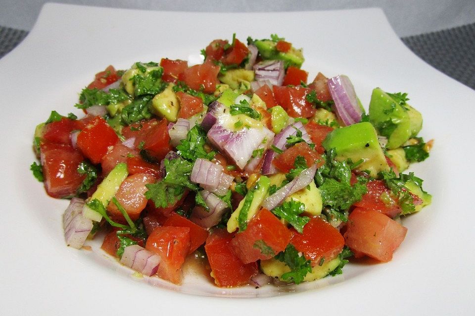 Tomatensalat mit roten Zwiebeln, Koriander, Avocado und Olivenöl