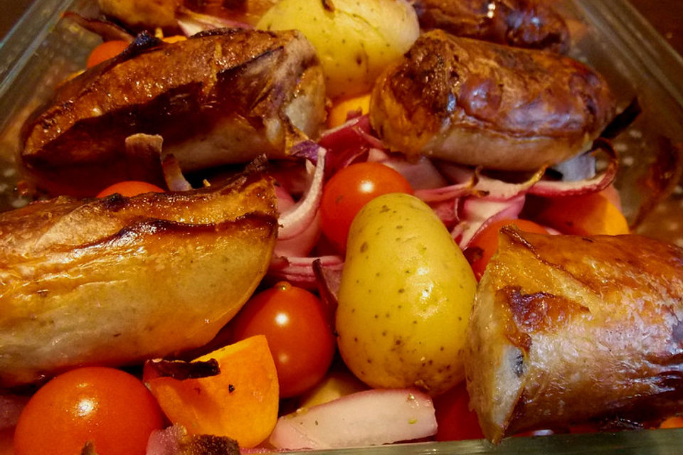 Gebackene karamellisierte Bratwürste mit Kartoffeln und Möhren