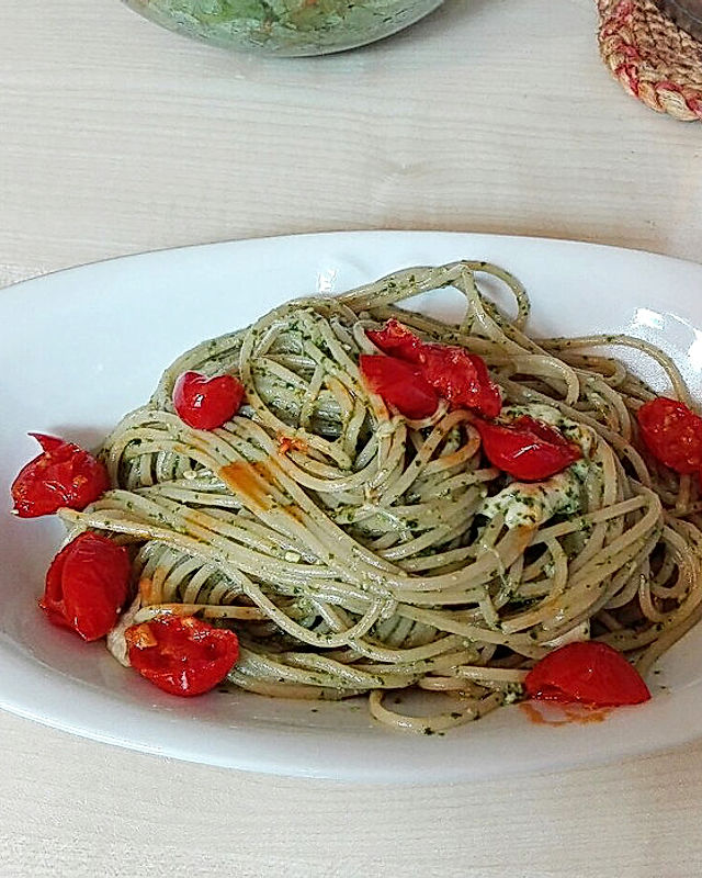 Vollkorn-Spaghetti mit frischem Basilikum-Pesto, dazu geschmolzene Tomaten und Mozzarella