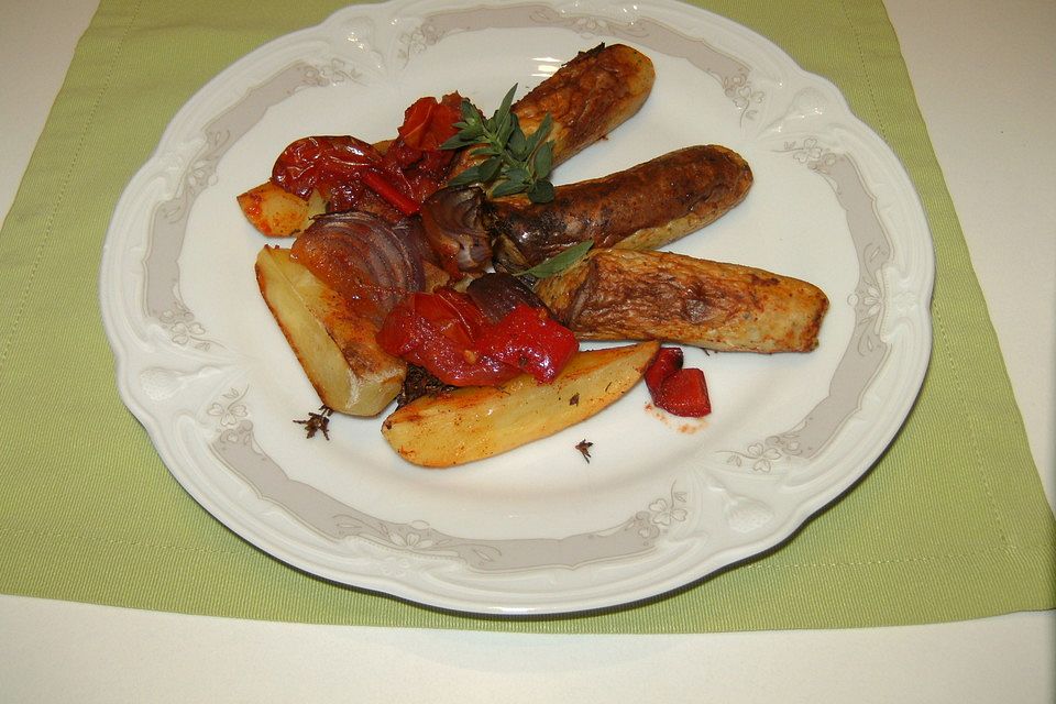 Gebackene Bratwürste mit Kartoffeln und Tomaten