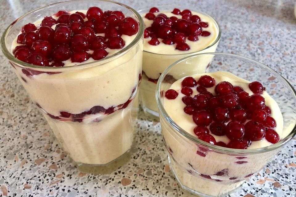 Mangocreme mit roten Johannisbeeren