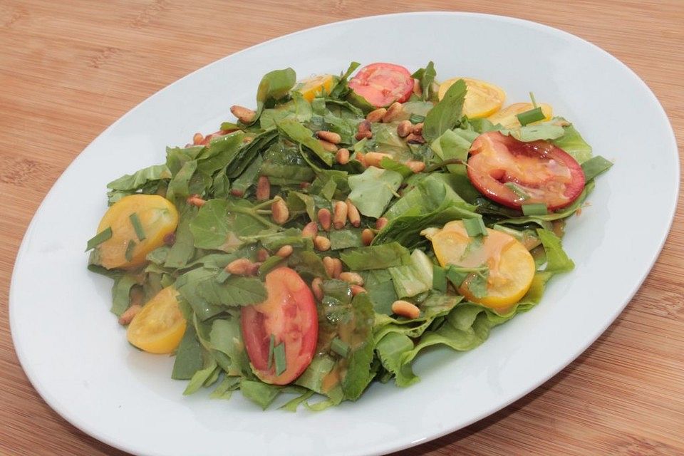 Endiviensalat mit Wildkräutern, bunten Tomaten und Senfdressing sowie Pinienkerntopping