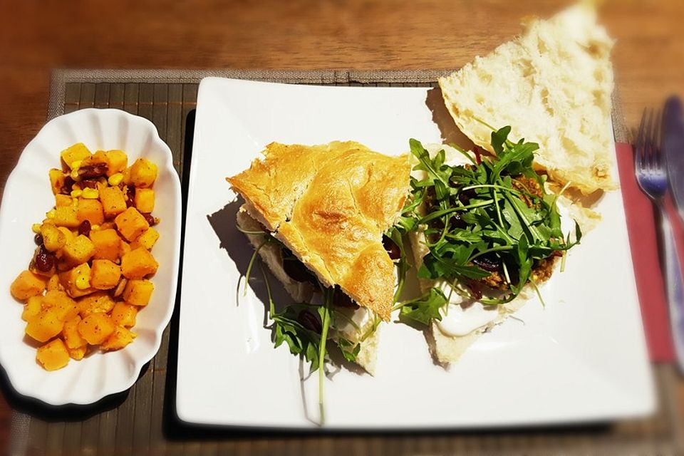 Gemüseburger in Fladenbrot auf Naturjoghurt mit Balsamico-Zwiebeln und Rucola