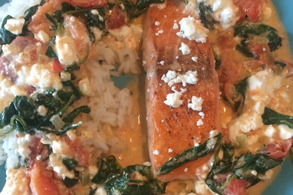 Lachsfilet auf Tomaten-Spinat-Soße sowie Feta und Reis