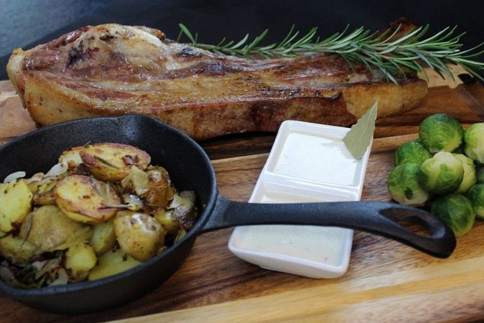 Eine ganze Kalbsrippe mit Rosenkohl und Bratkartoffeln