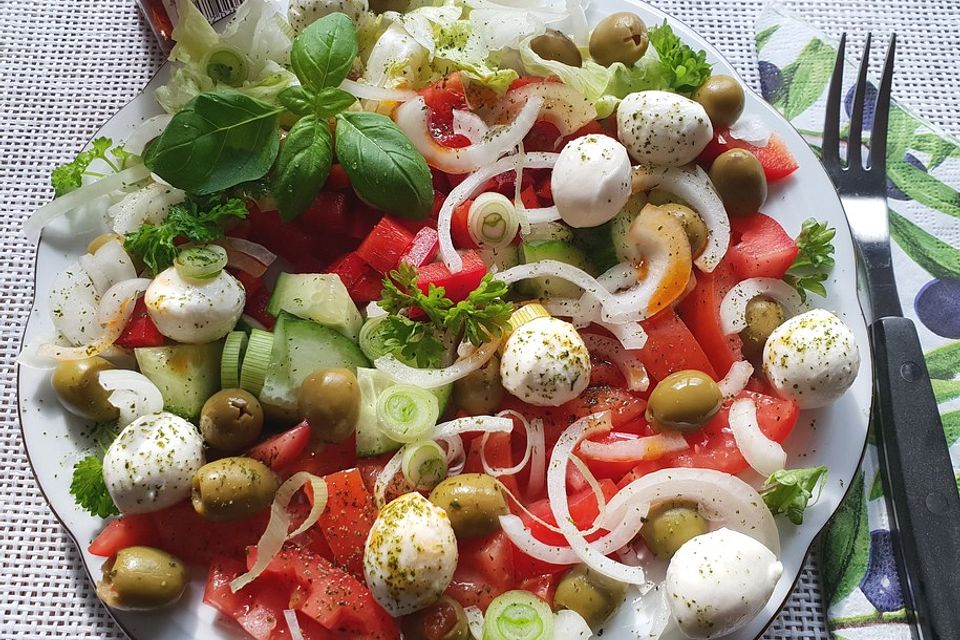 Salat mit Oliven, Mini-Mozzarella, Paprika, Tomaten, Zwiebeln und Chiliöl