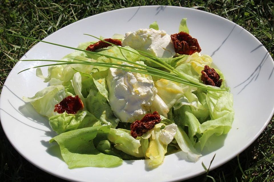 Kopfsalat an Frischkäsenocken und getrockneten Tomaten mariniert mit feinem Senfdressing