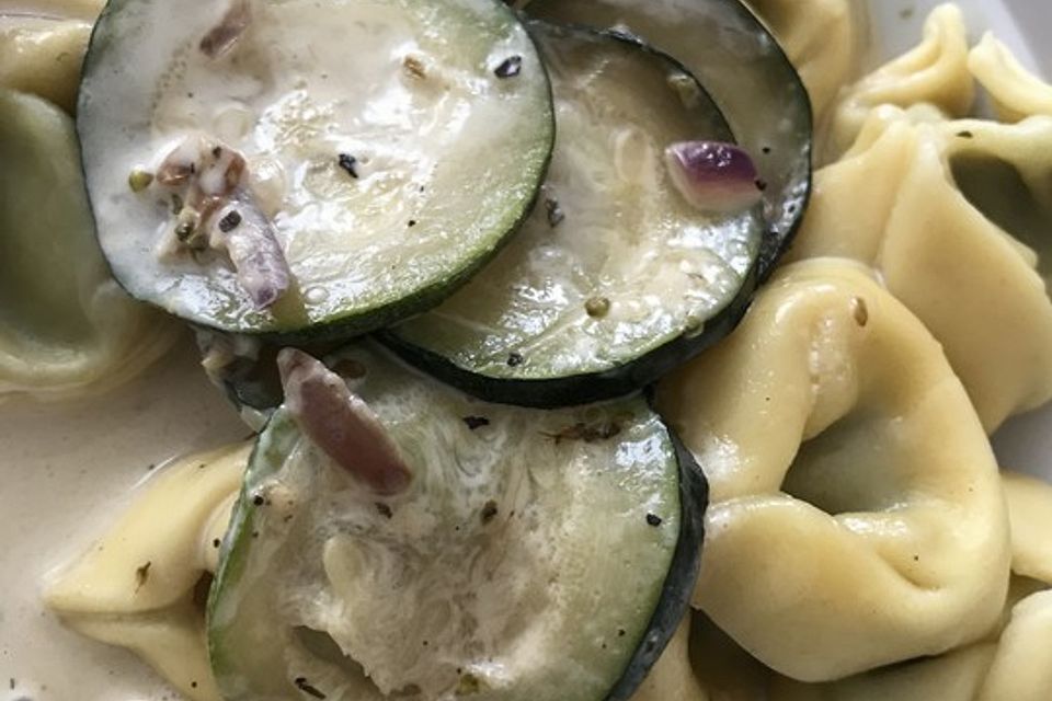 Tortellini in Zucchini-Sahnesauce mit roten Zwiebeln