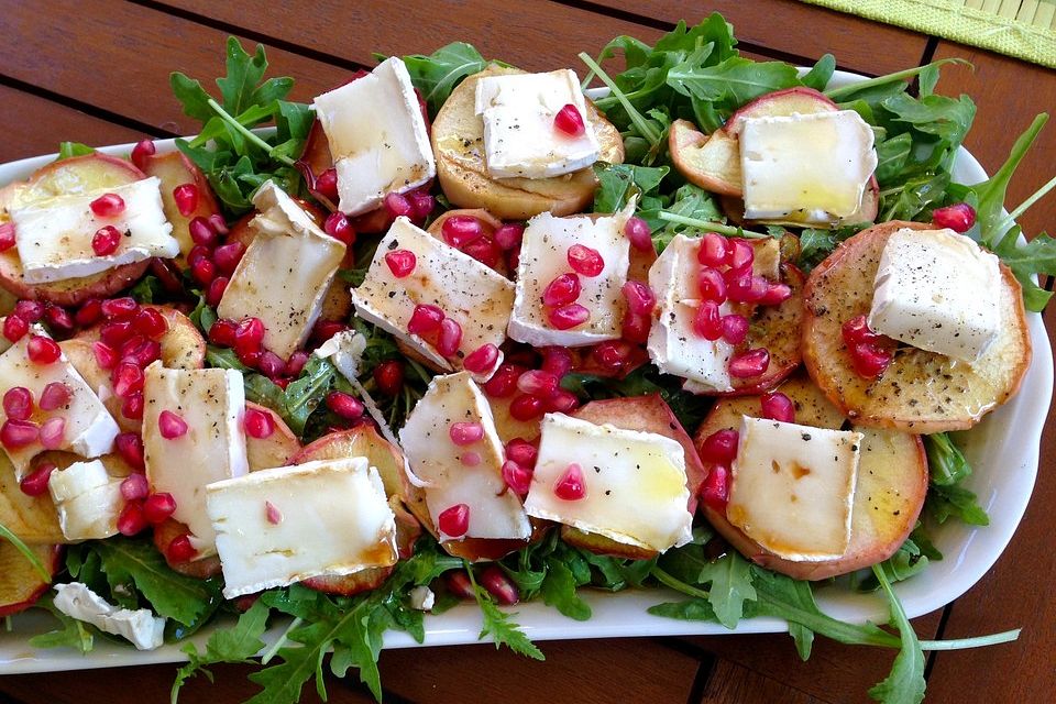 Trio von Ziegenkäse, Honig-Apfel und Granatapfel auf Rucolabett