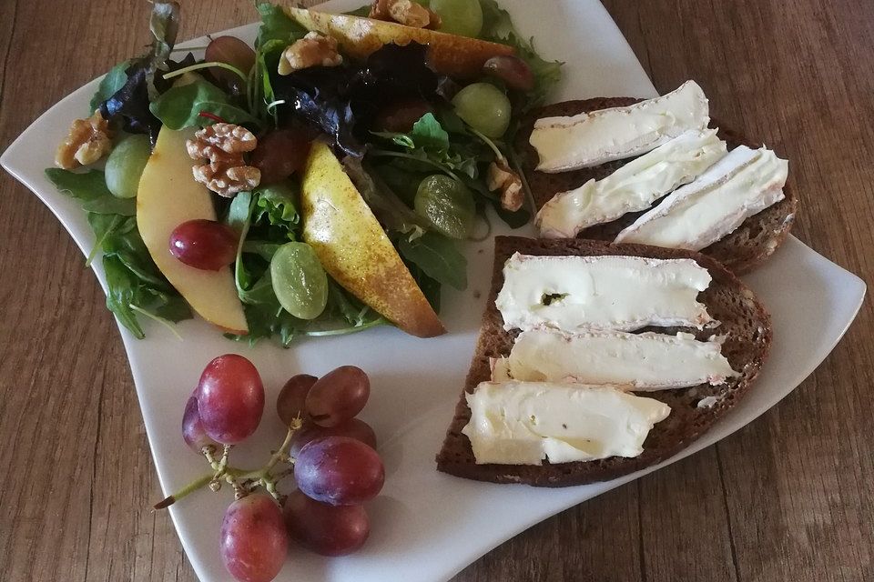 Traubensalat mit Nüssen und Birnen an gerösteten Brotscheiben mit Camembert