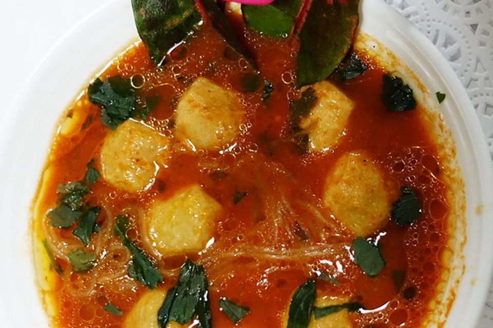 Würzig-exotische Tomatensuppe mit Hühnerfleischbällchen und Glasnudeln.