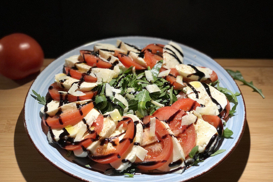 Rucolasalat mit Tomaten, Mozzarella, Parmesan und Balsamico