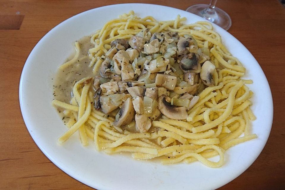 Hähnchengeschnetzeltes mit Champignons in einem Spätzlebett