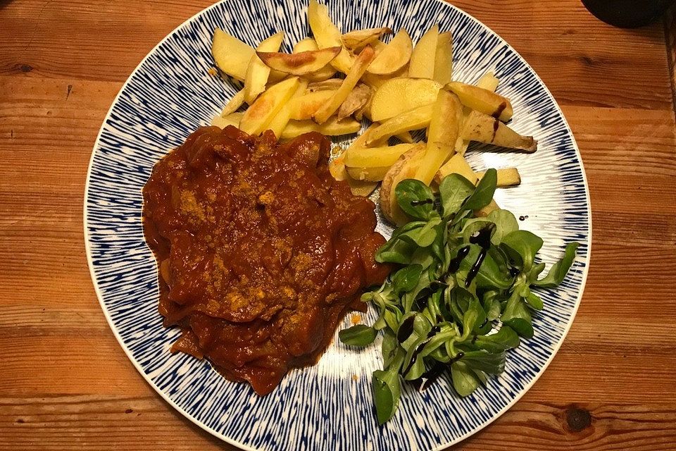 Vegane Currywurst mit Kartoffel-Wedges und Feldsalat