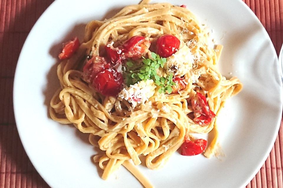 Tagliatelle con pesto e formaggio di capra e pomodori