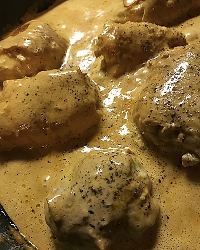 Mit Schafskäse gefüllte Hähnchenbrust im Baconmantel in Curry-Sahnesauce