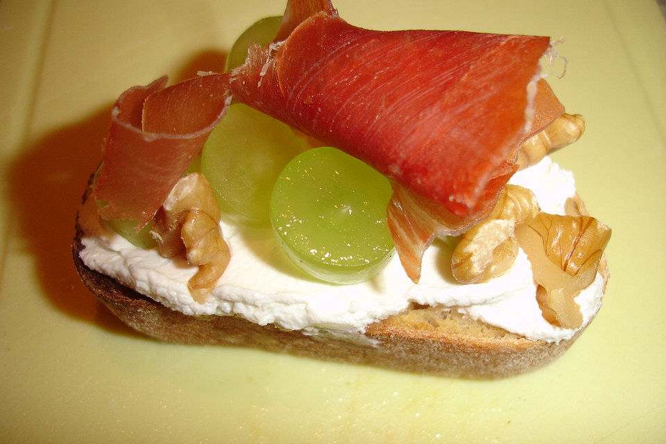 Crostini mit Ziegenfrischkäse, Trauben, Walnüssen und Schinken