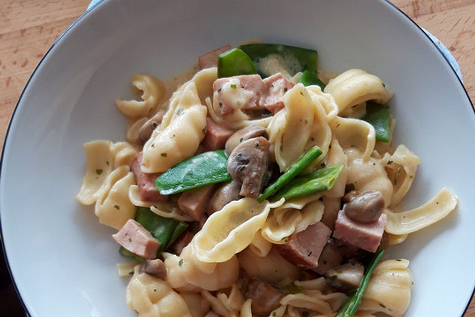 Champignon-Zuckerschoten-Pfanne mit Nudeln und Fleischkäse