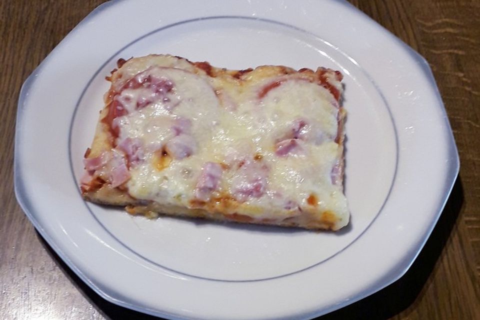 Pizza mit Tomaten, Schinken und Käse