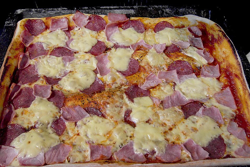 Pizza mit Tomaten, Schinken und Käse