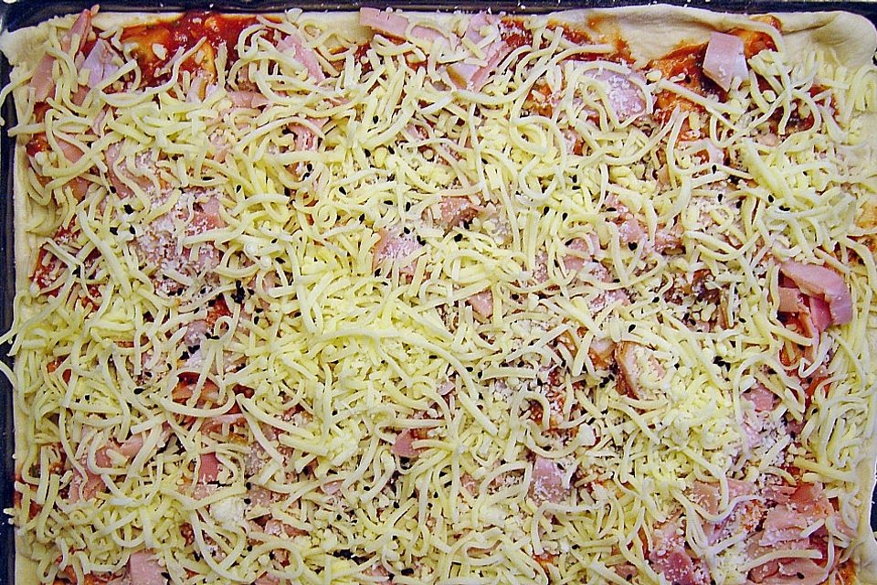 Pizza mit Tomaten, Schinken und Käse