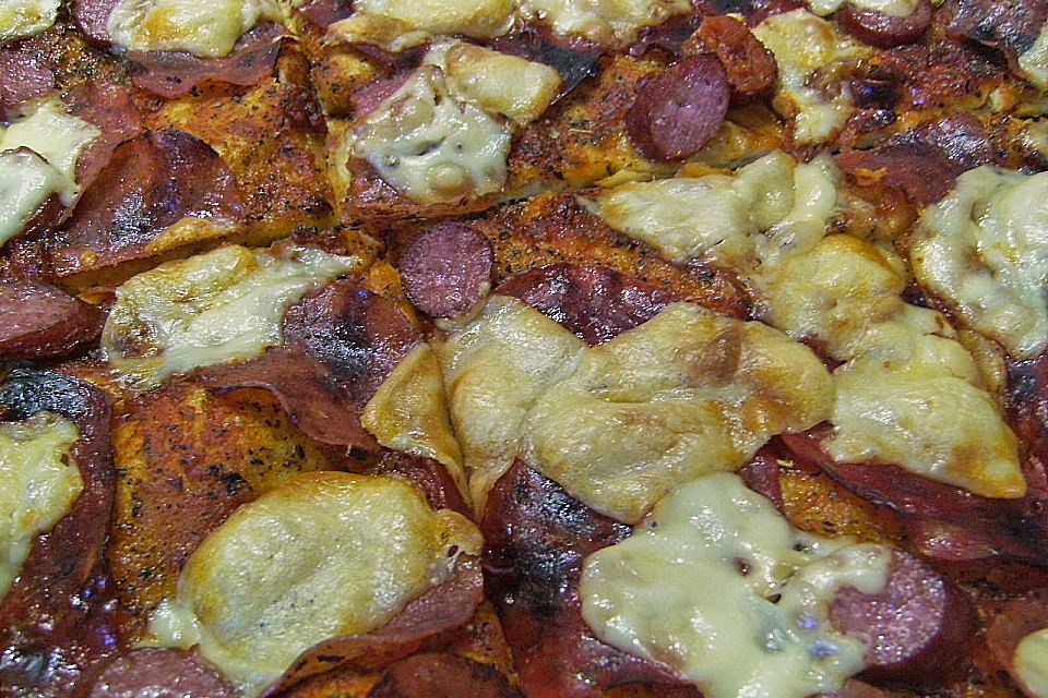 Pizza mit Tomaten, Schinken und Käse