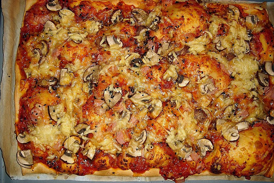 Pizza mit Tomaten, Schinken und Käse