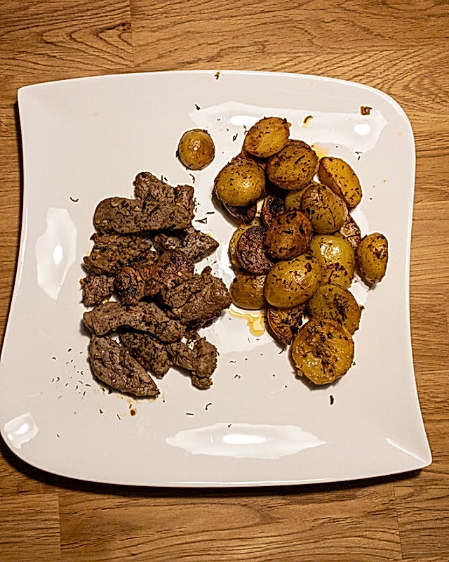 In Knoblauchbutter gebratene Steakstreifen mit Kartoffeln