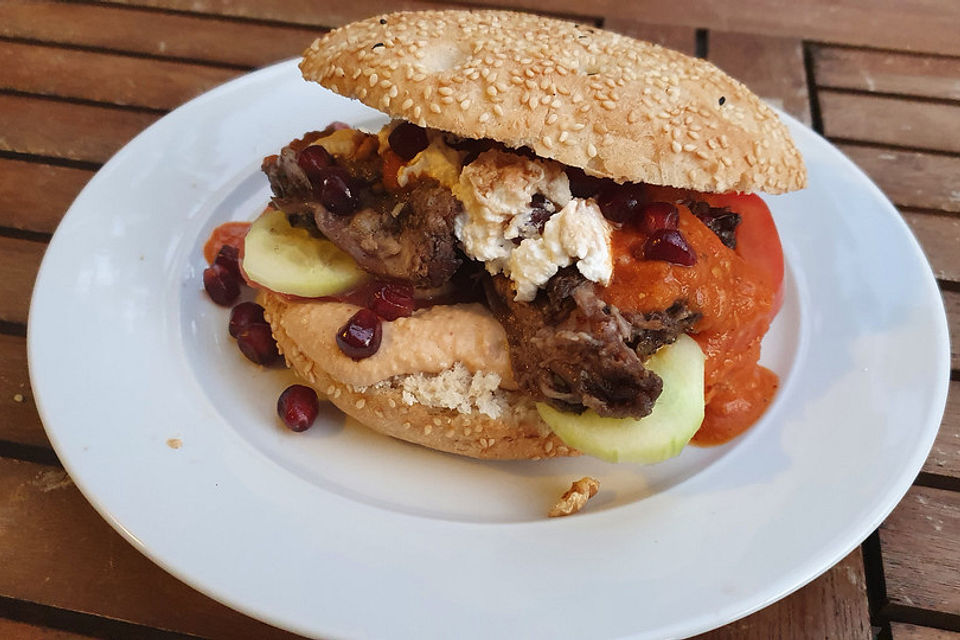 Gezupfte Lammschulter im Fladenbrot mit Hummus, Labneh und scharfer Sauce